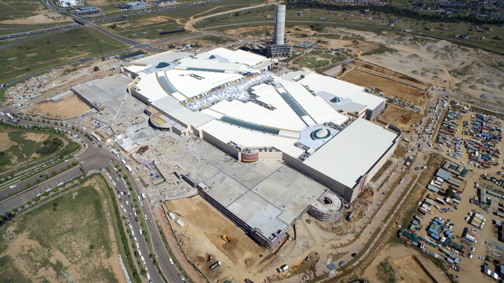 Aerial view showing mall roof and skylight facade completed, ongoing carpark construction and PwC tower under construction in background (mallofafrica.co.za)