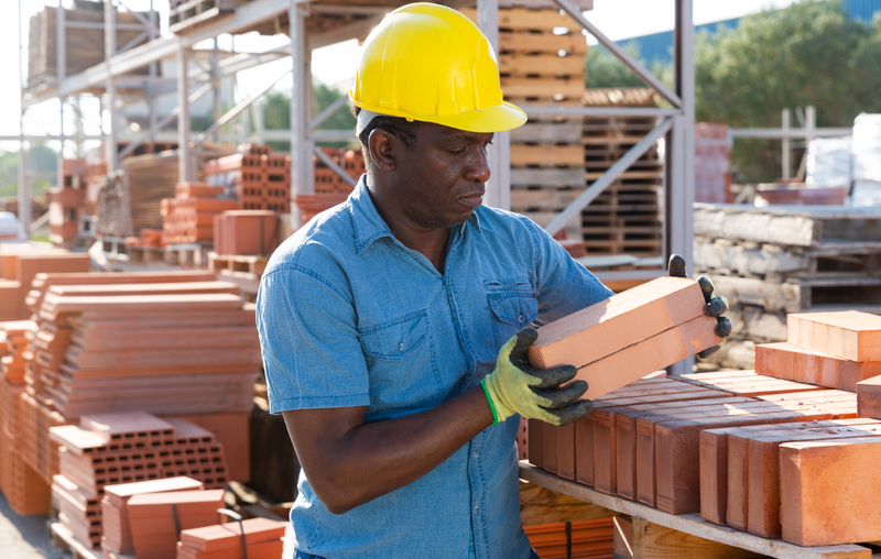 Construction worker carrying bricks (Jackf | Dreamstime)